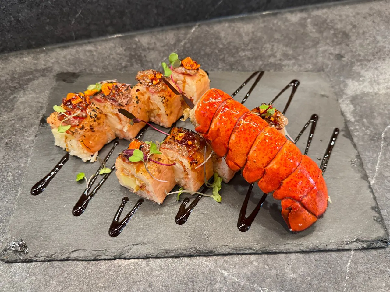 Sushi roll with lobster tail and savory toppings on slate at The Shoya, a Japanese Restaurant in Pleasant Hill